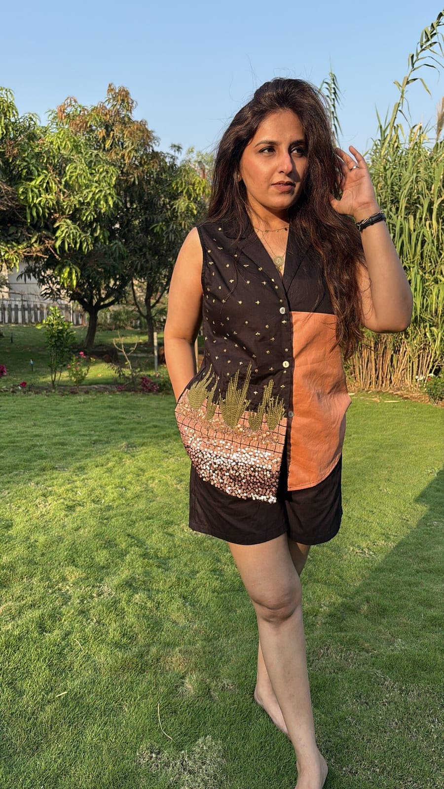 Sleeveless shirt blocked in black and terracotta, worn with matching black shorts, gold cacti and sequins running across the lower front.