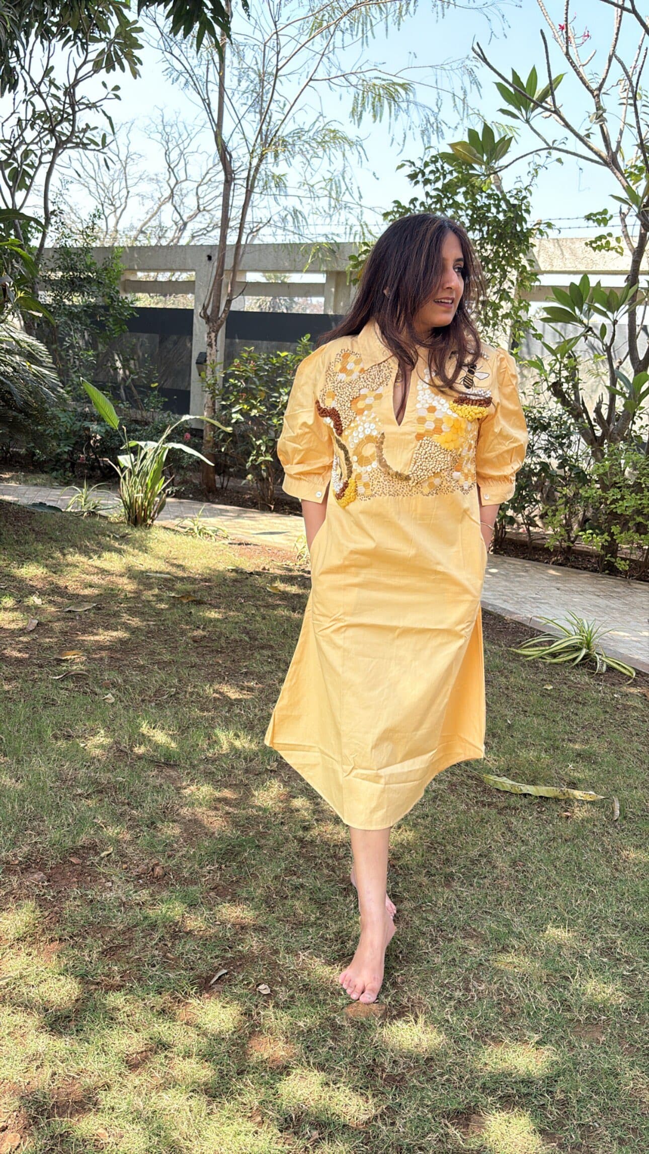Model wearing a hand-embroidered Keysh dress with beaded honeycomb and bee work