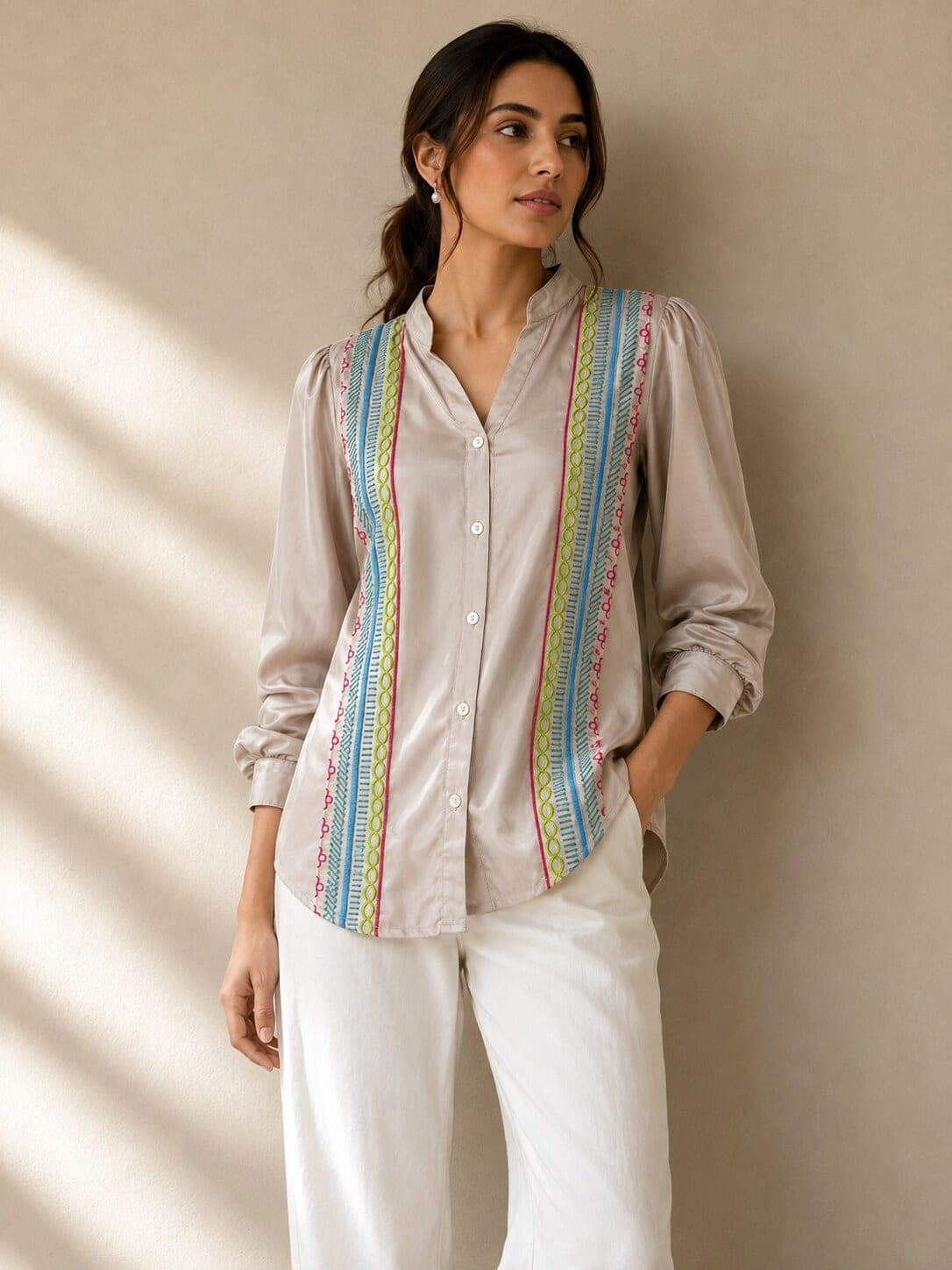 Model wears a pale grey cotton shirt with vertical lime, turquoise and magenta cord embroidery flanking the button placket.