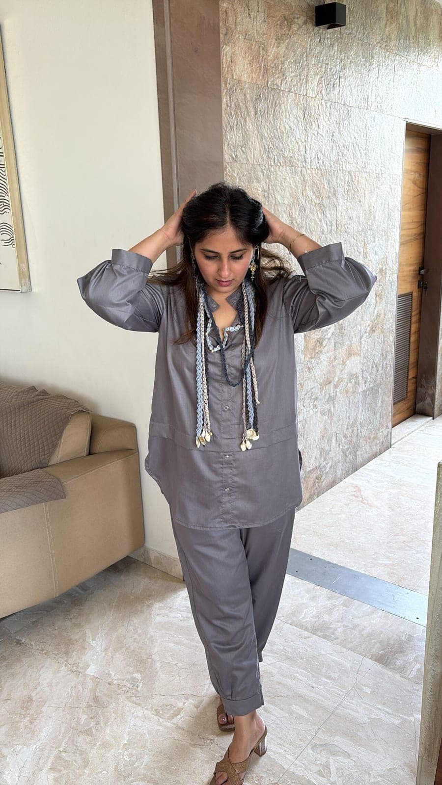 Slate grey viscose-blend co-ord worn indoors — collared shirt with wide turned-back cuffs and matching straight trousers cuffed at the ankle.